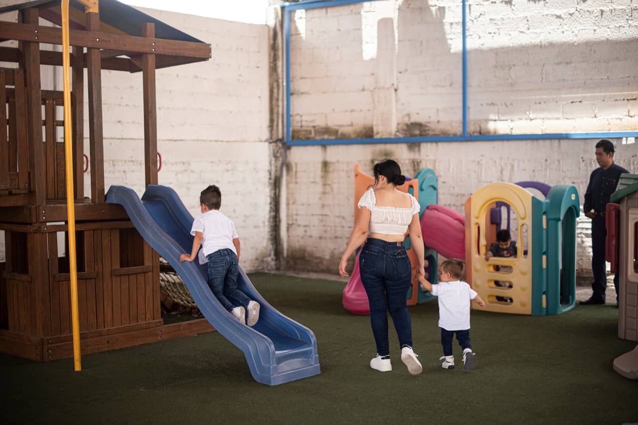 Niños jugando en la resbaladilla y los juegos del área infantil de Parador del Valle