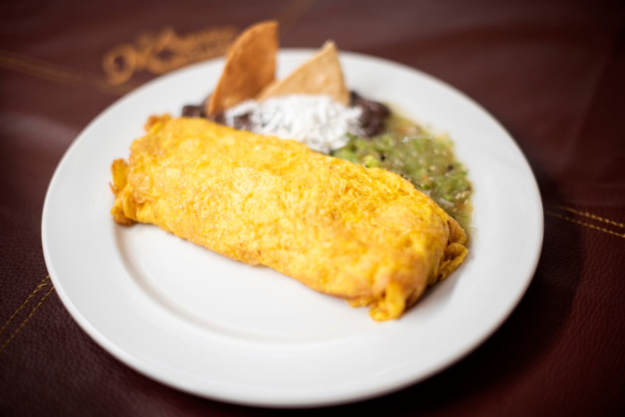 Omelette con frijoles, salsa verde y totopos servido como desayuno