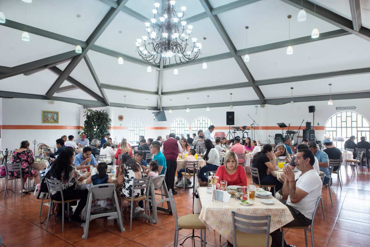 Salón de Parador del Valle lleno de comensales bajo el candil central